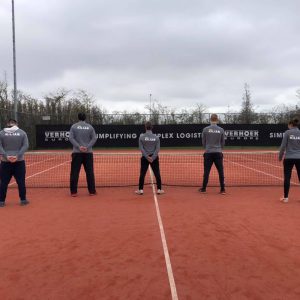 Vijf tennistrainers op een tennisbaan