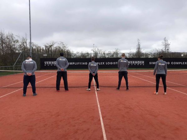 Vijf tennistrainers op een tennisbaan